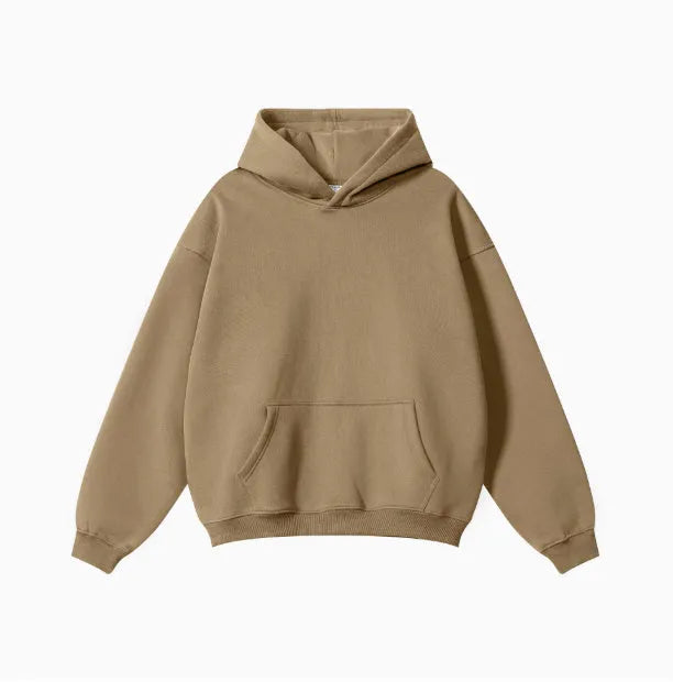 Man wearing a grey heavyweight cotton terry hooded sweater with a loose fit and drop-shoulder sleeves.