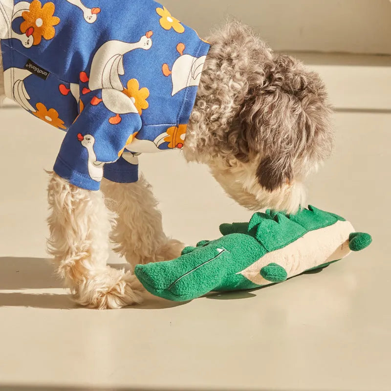 Green soft plush dog toy with embroidered face featuring squeaker and rattle for infant play