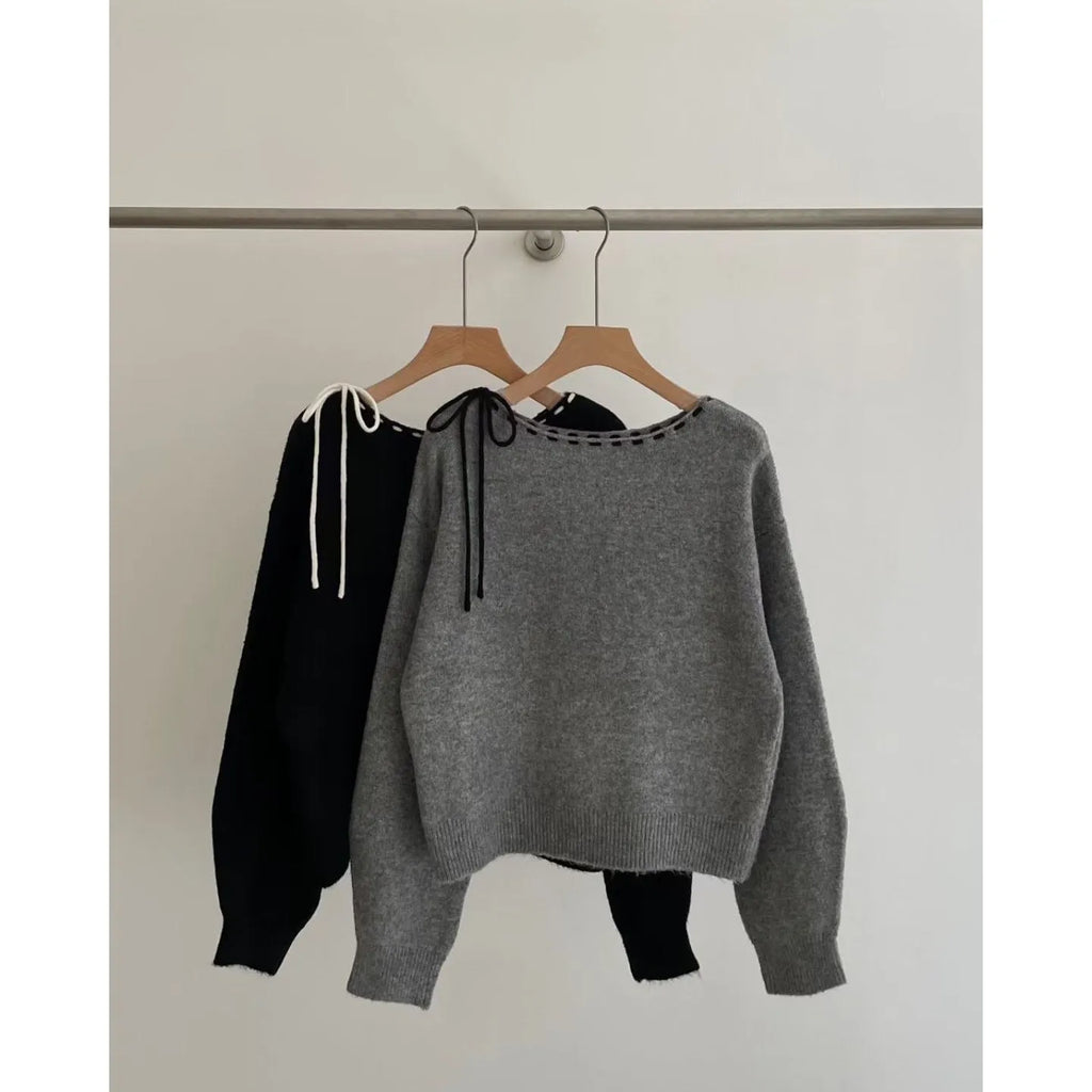 Grey loose-fitting women's long sleeve pullover sweater on a hanger