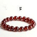 Close-up of an orange red garnet crystal bracelet with retro styling and Ruyi design details.
