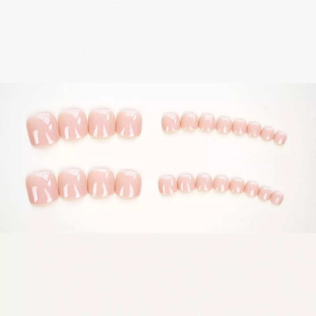 Set of ten skin-colour plastic artificial toenails and a bottle of glue for pedicure enhancement.