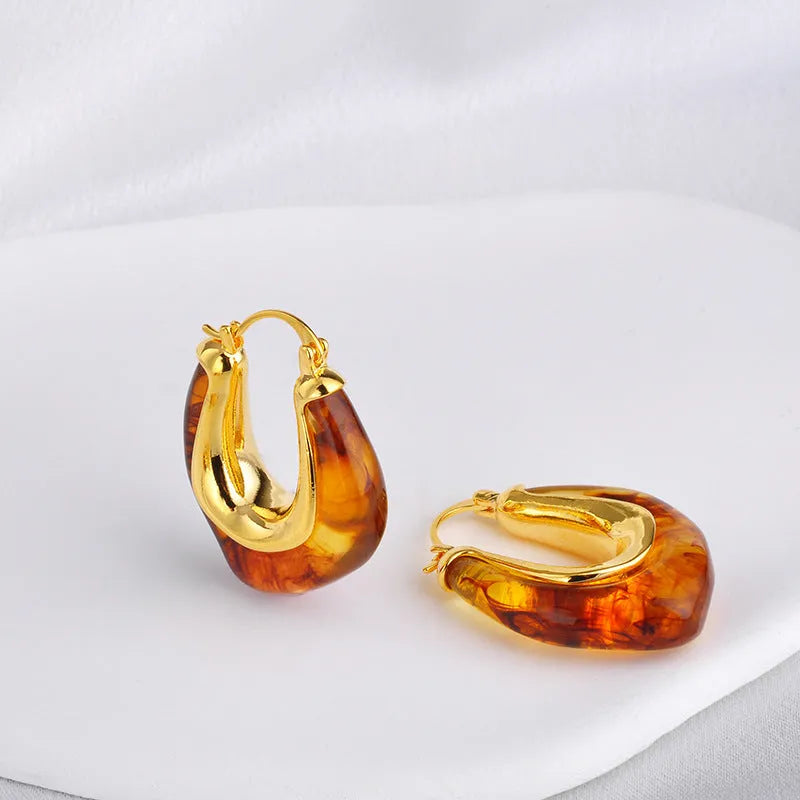 Copper geometry shape retro Maillard style earrings with electroplated finish in amber colour option on plain background