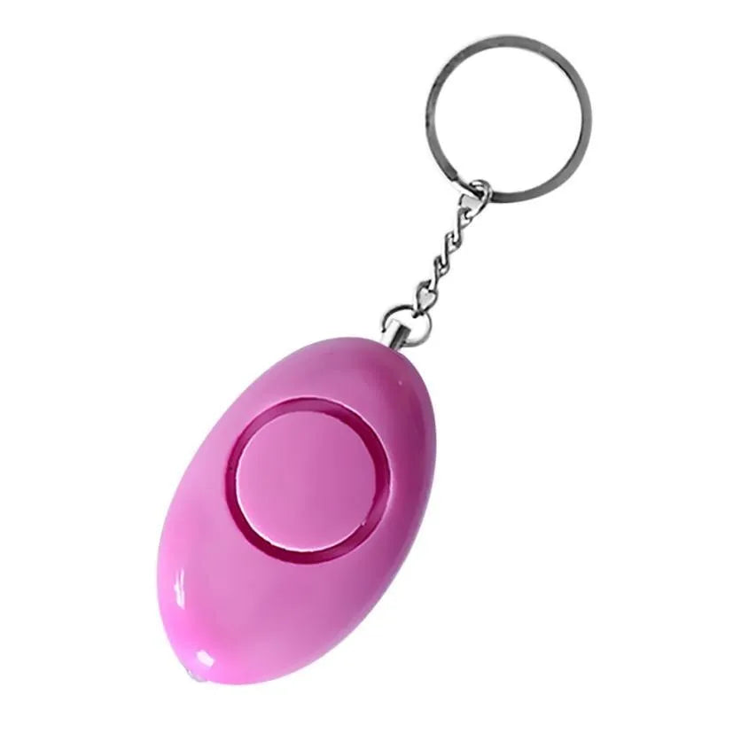 Egg-shaped personal safety alarm keychain in pink with metal pin on a white background