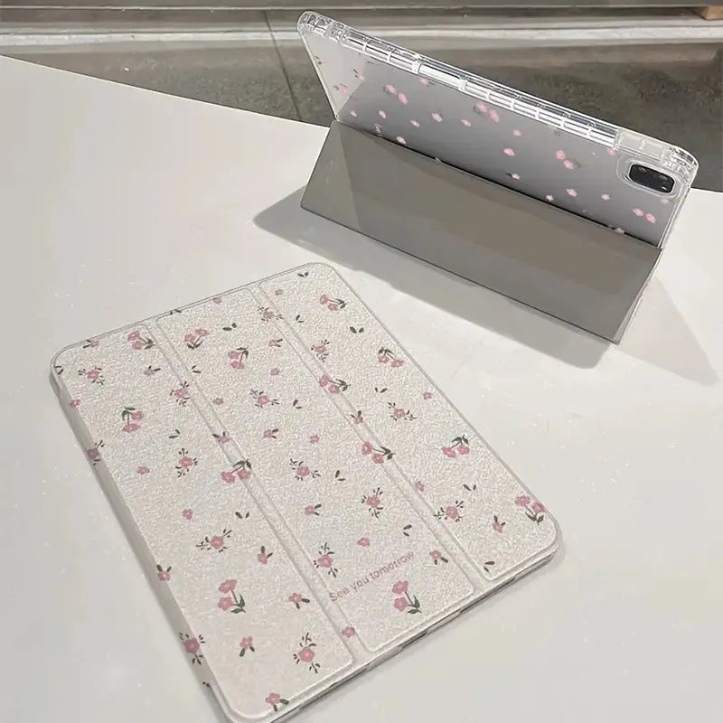 Clear iPad case with floral cartoon pattern, shown folded into a stand position.
