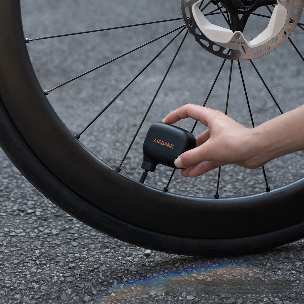 Black AS100 electric bicycle pump with USB charging cable and waterproof storage bag