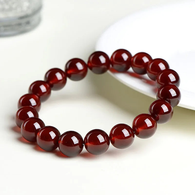 Close-up of an orange red garnet crystal bracelet with retro styling and Ruyi design details.