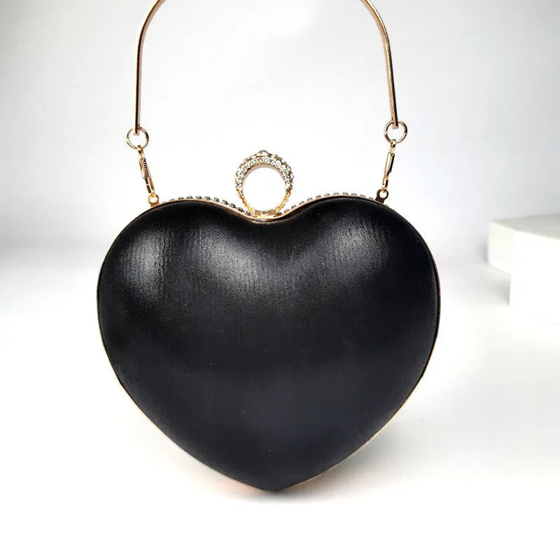 Women's heart-shaped metal dinner bag with tassel detail in black, gold, and silver options