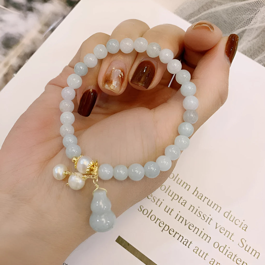 Chinese style jade bracelet with gourd design and pearl accents in natural emerald colour