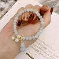 Chinese style jade bracelet with gourd design and pearl accents in natural emerald colour