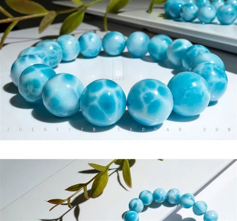 Blue handmade bodhi bracelet with natural sea-pattern crystal beads and pearl details on a wrist.