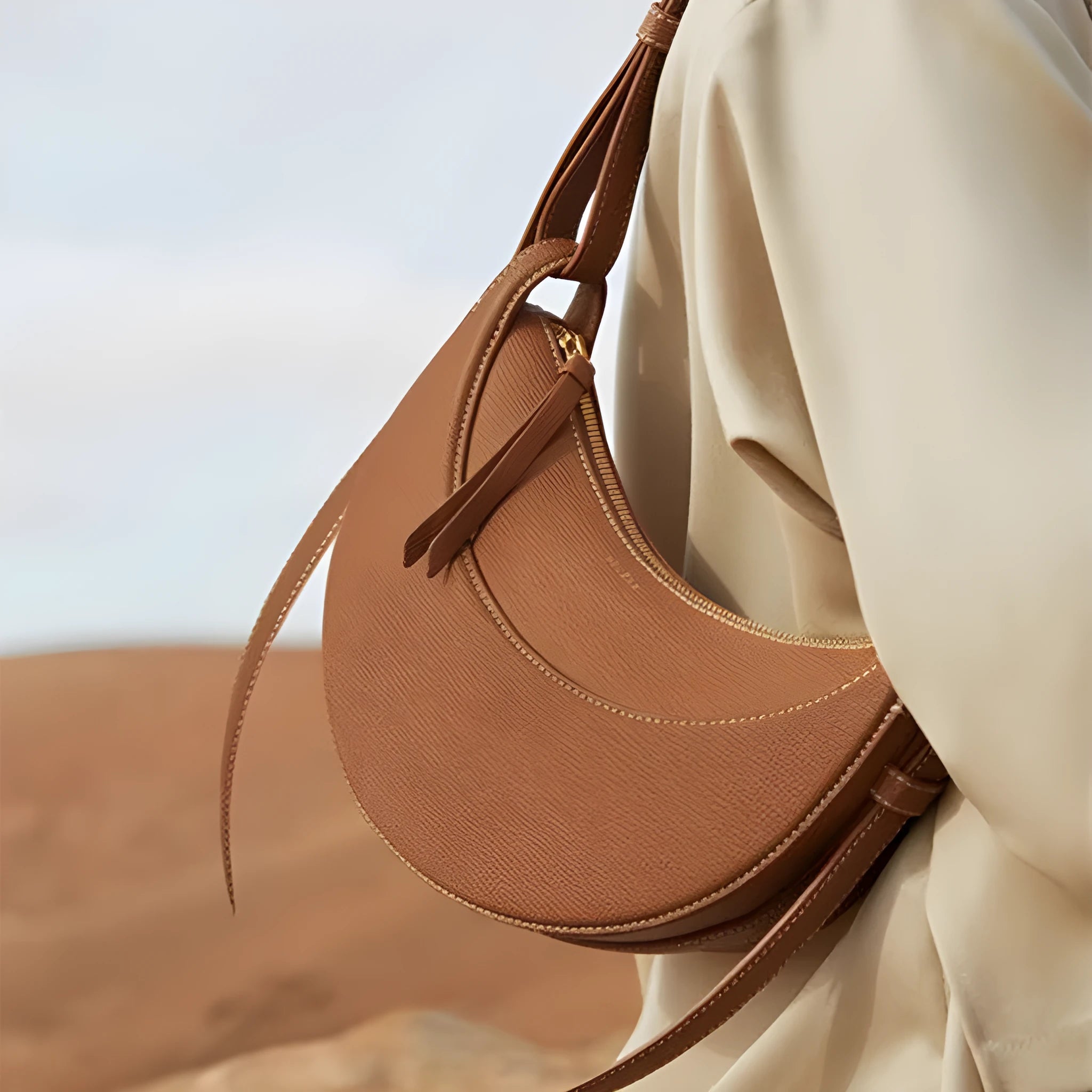 Women's crescent shoulder bag with litchi pattern texture, available in camel, black, chalk white, and elephant gray