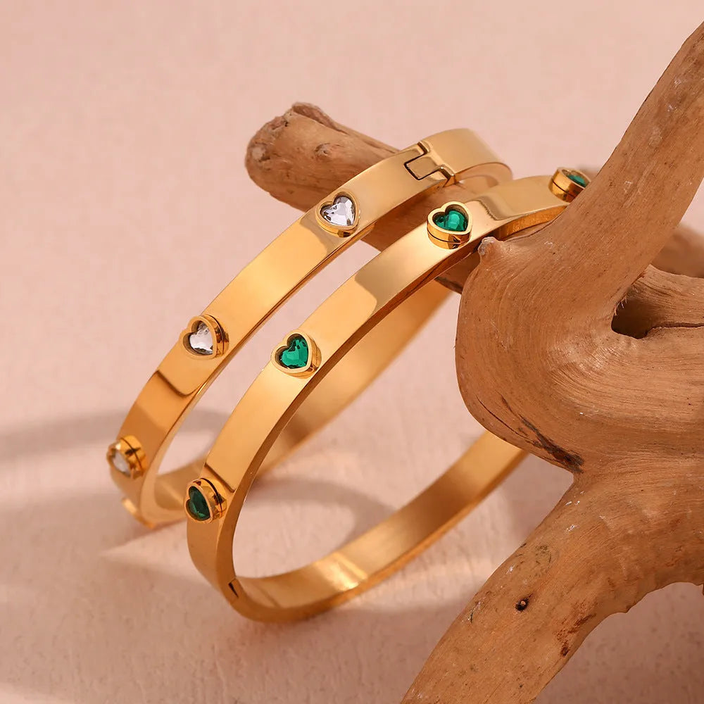 Stainless steel bracelet with a micro-inlaid peach heart charm in a golden electroplated finish.