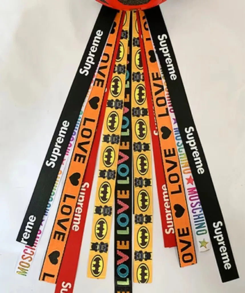 Colourful fabric helmet streamers for children's roller skating and ski helmets, shown in apricot, red, and grey.
