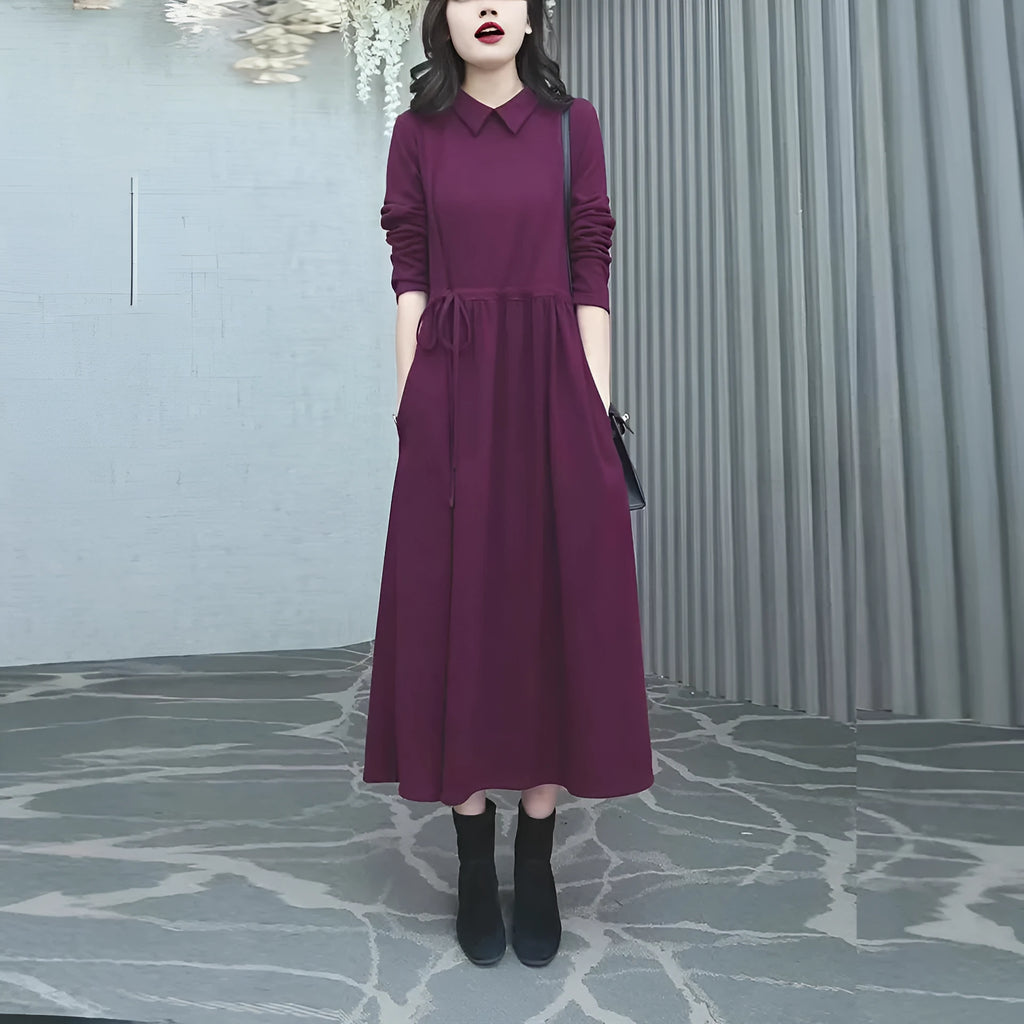 Purplish red long sleeve dress for women on a hanger, showing long skirt and extra long sleeves.