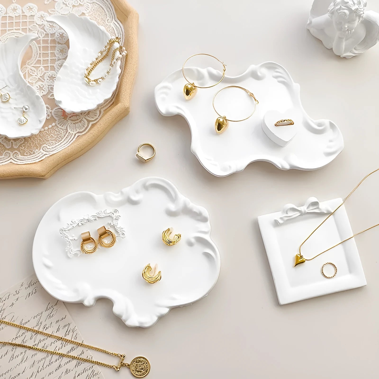 European Baroque style gypsum jewellery display plate with rings and earrings on a dressing table