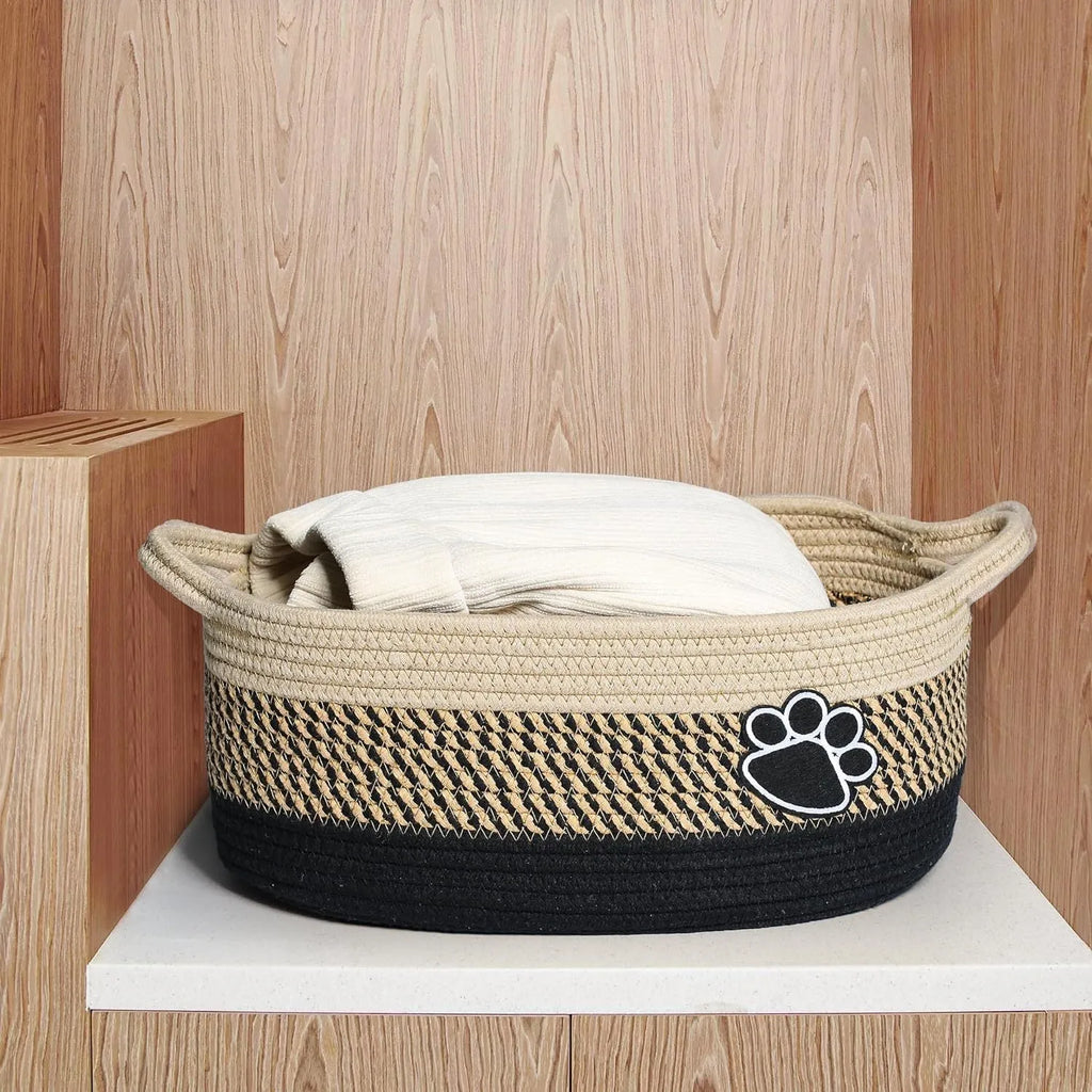 Light beige handmade cotton rope storage basket with a handle on a wooden floor.