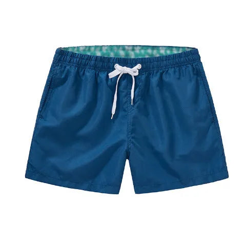 Men's straight-leg beach shorts in polyester fabric on a beach background