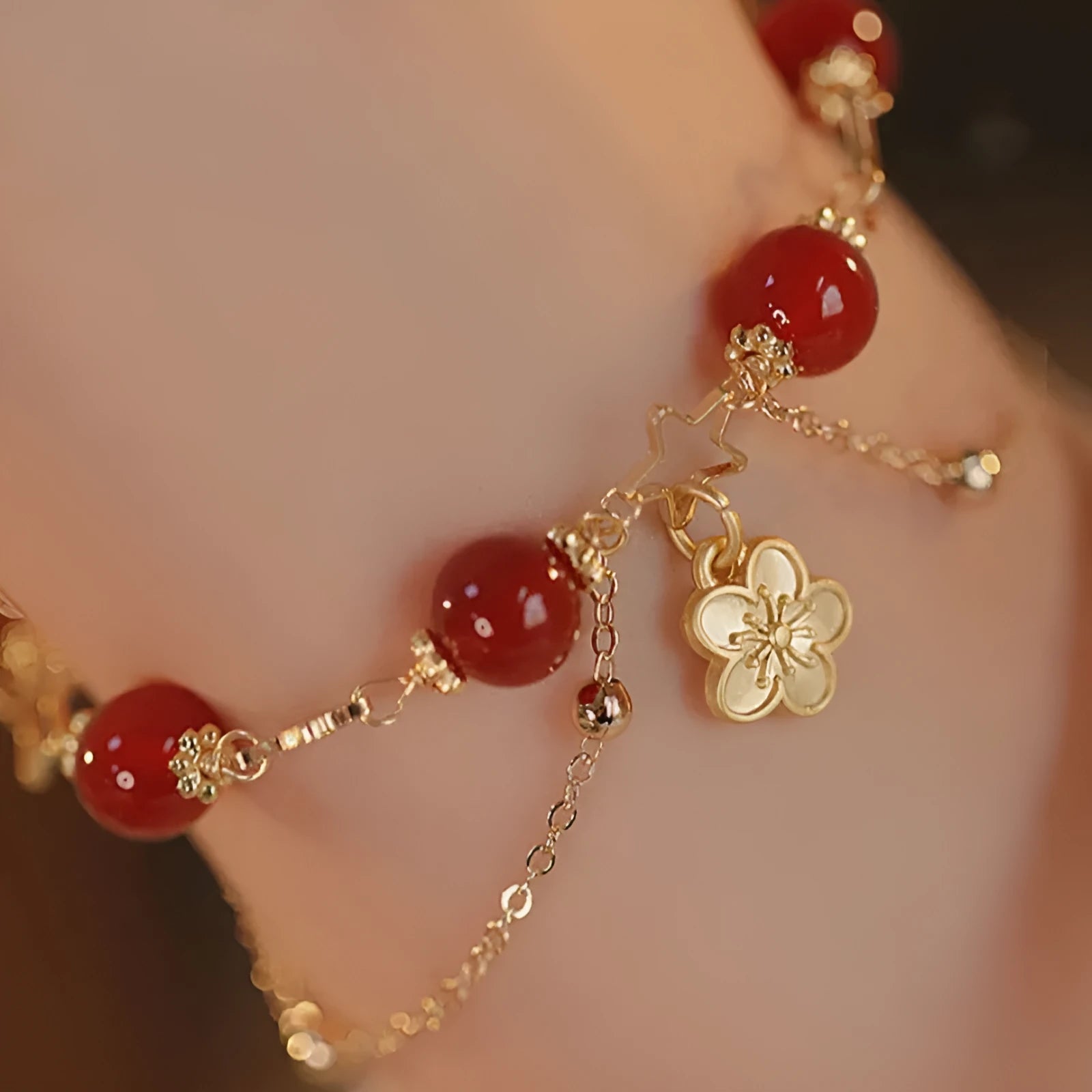 Handmade red agate double layer bracelet with floral peach blossom design on a white background.