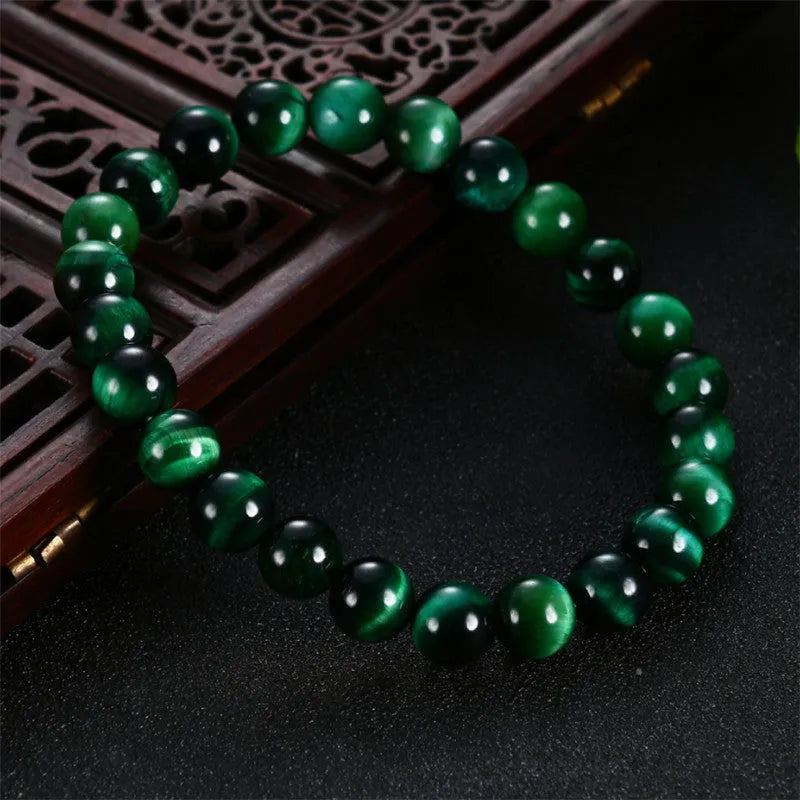 Green Natural Tiger Eye stone bracelet with geometric beads on a wrist.