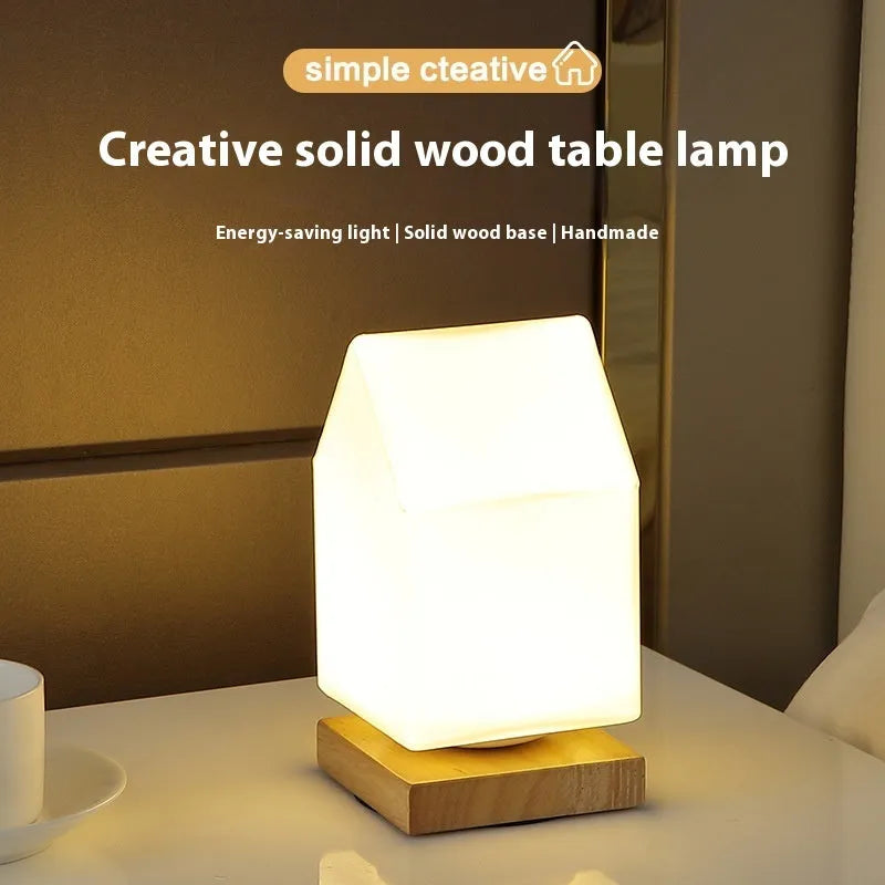 Nordic solid wood base USB table lamp with a white geometric shade on a wooden table.