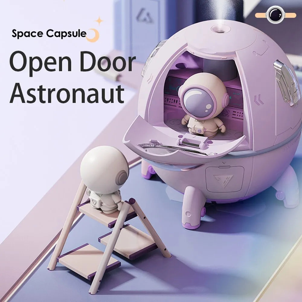 Purple astronaut-themed desktop USB humidifier with LED light next to USB cable on a desk.