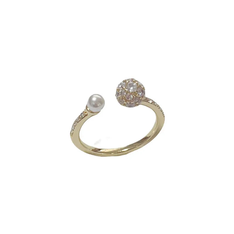 Golden open-end ring with a round zircon stone on a simple geometric band.