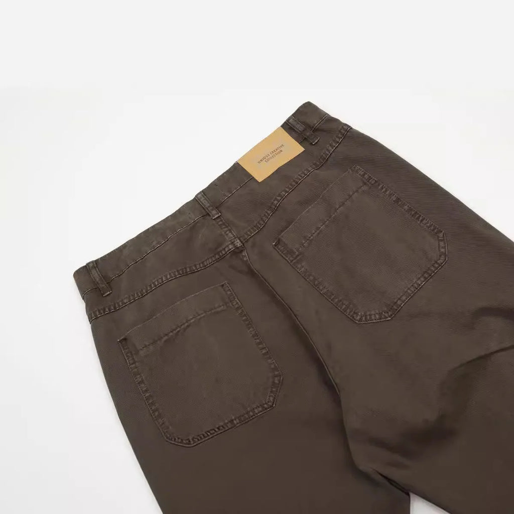 Men's loose straight-leg cotton trousers in brown, showing high waist and zipper fly.