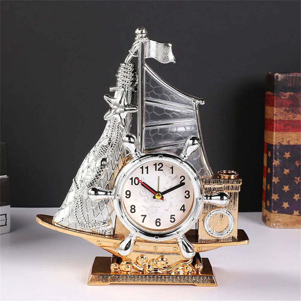 Modern metallic-finish bedroom alarm clock in gold or silver on a bedside table.