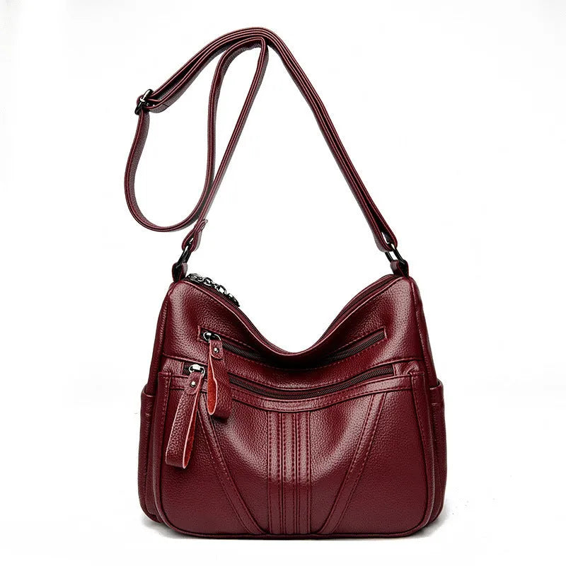 Genuine leather horizontal square messenger bag in black with contrast stitching and a front slit pocket.