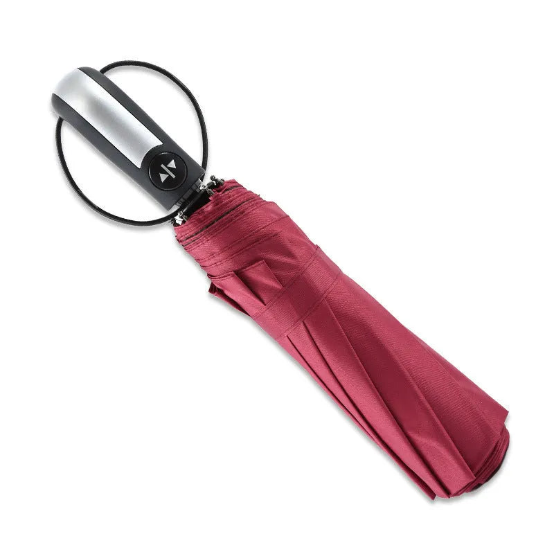Black triple folding automatic business umbrella with 10 ribs and a rubber handle, shown open.
