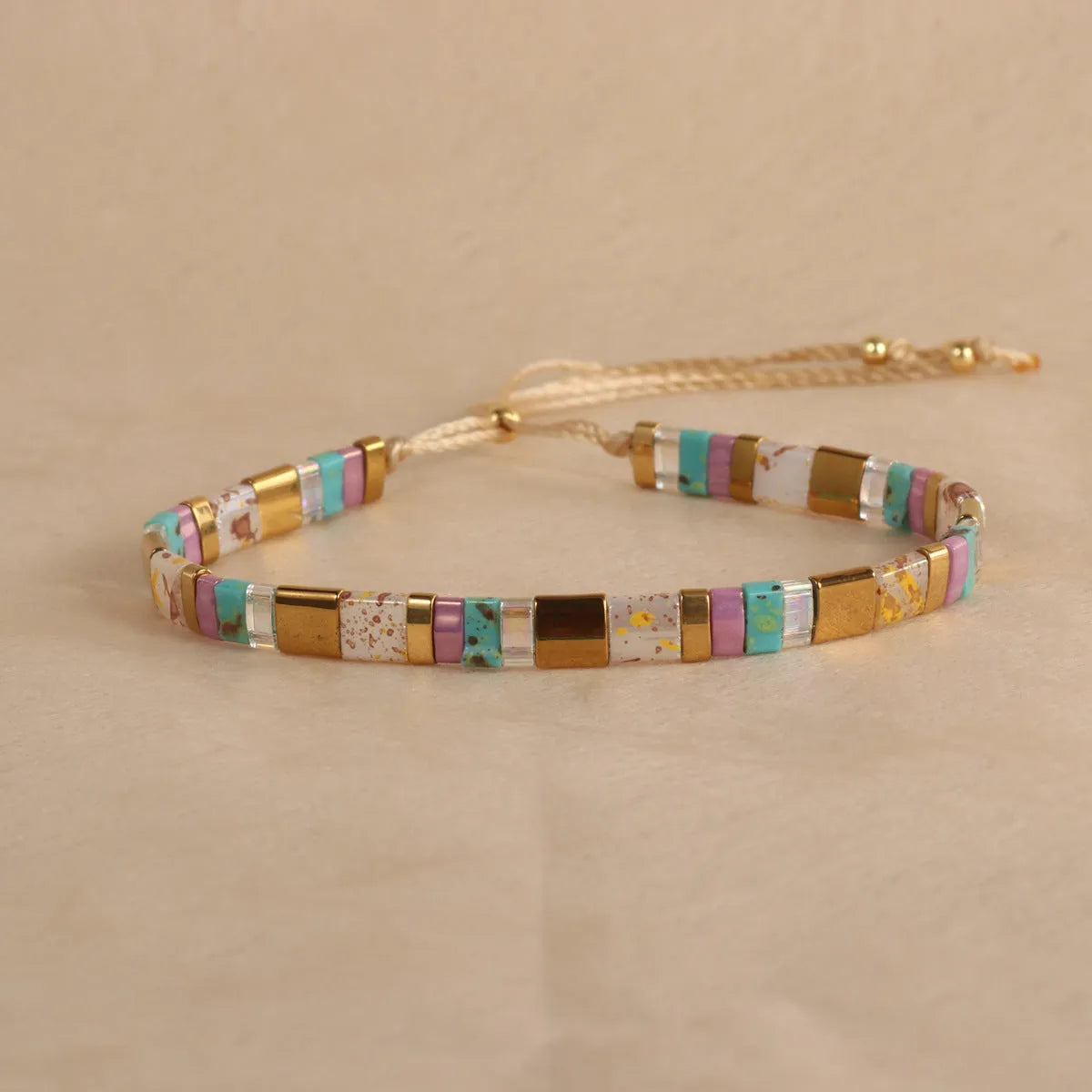 Geometric round glass bead bracelet in milky white, black, green, blue, or red.