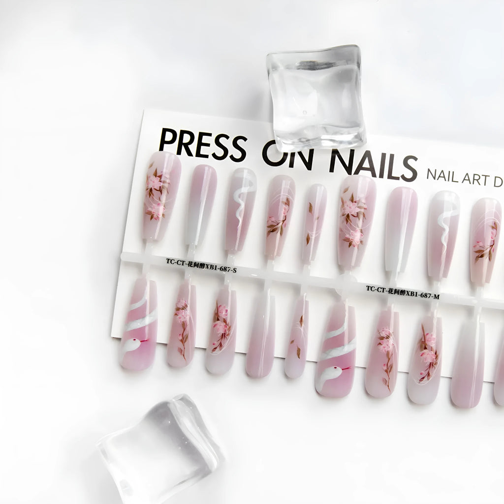 Ancient Chinese style snake year red prefabricated nail tips in drunk flower colour, long ladder shape, on a display stand