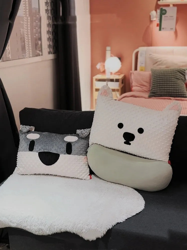Grey schnauzer and white West Highland puppy decorative cushion pillow on a sofa.