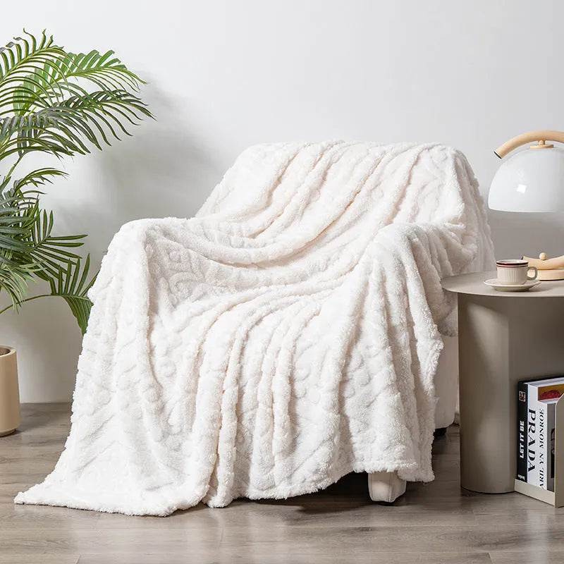 Shu cotton velvet jacquard sofa blanket with plant flower pattern in solid colour on a grey sofa.