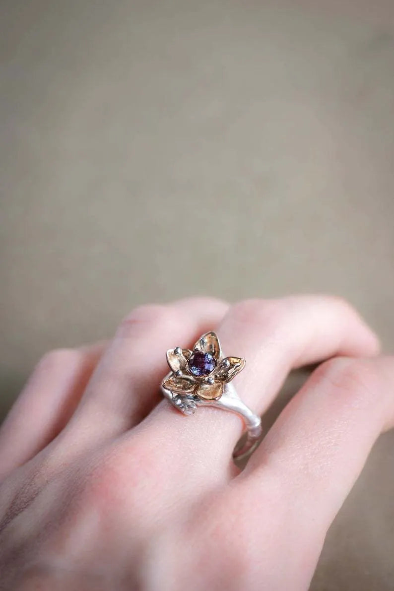 Silver two-tone floral design women's alloy ring on a simple geometric band.