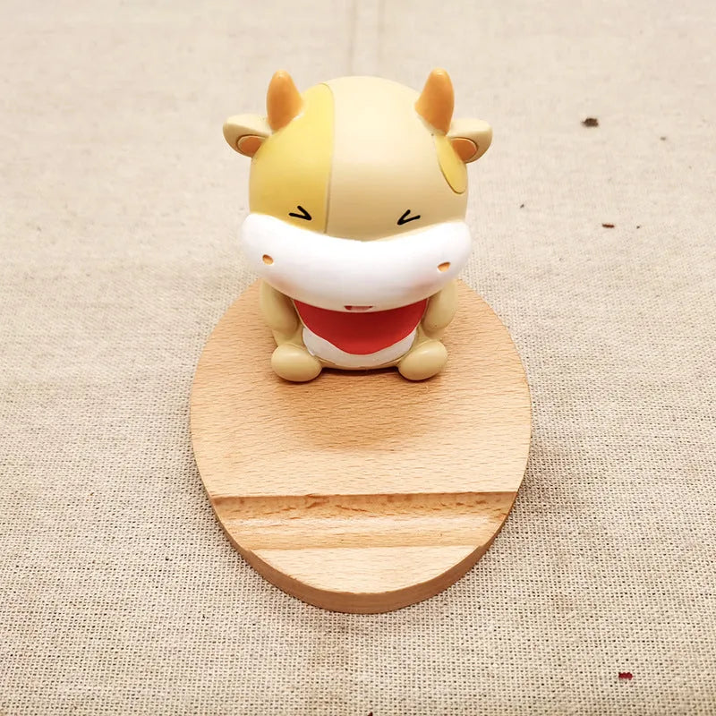 Decorative resin mobile phone stand in a choice of styles including animal figures and wood-effect designs.