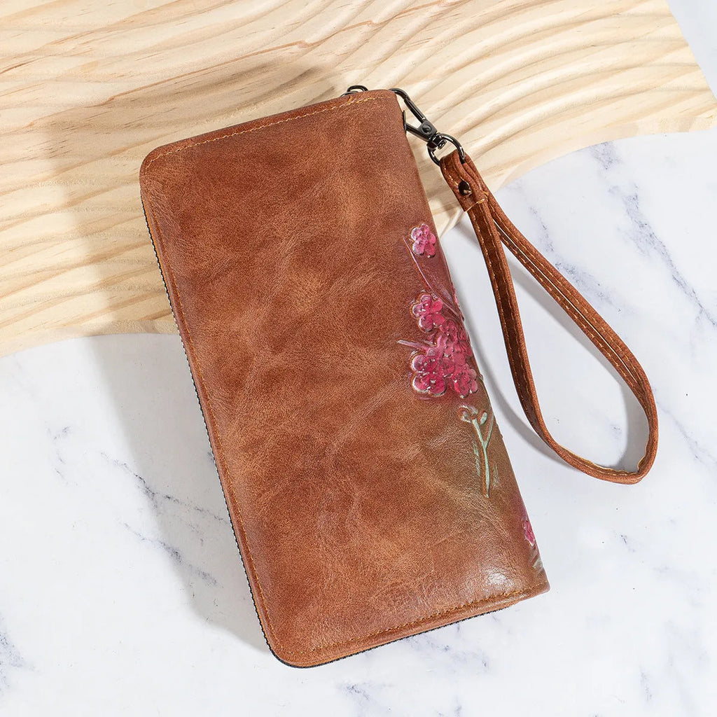 Retro brown handbag with embossed floral design and a large metal YKK zipper.