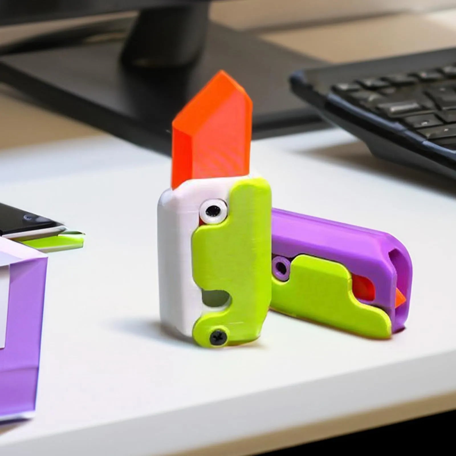 Carrot-shaped 3D printed plastic gravity fidget knife with orange purple green colour scheme