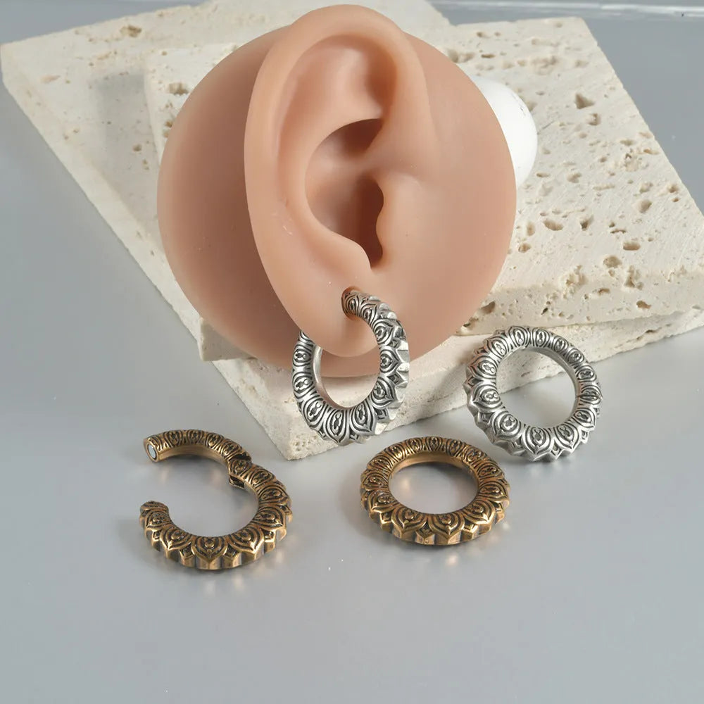 A pair of antique silver alloy earrings in a geometric dragon shape with hollow out design.