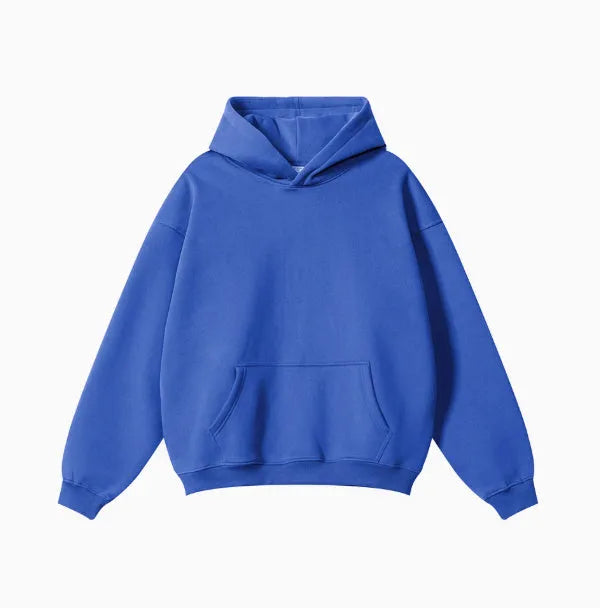 Man wearing a grey heavyweight cotton terry hooded sweater with a loose fit and drop-shoulder sleeves.