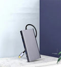 Silver 10-in-1 USB-C docking hub for MacBook with multiple ports including HDMI, USB, and SD card slots.