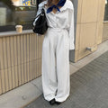 Women's white striped wide-leg trousers with front zipper closure on hanger