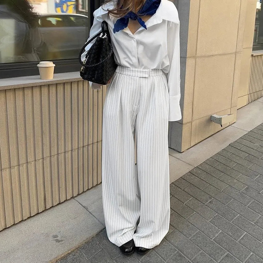 Women's white striped wide-leg trousers with front zipper closure on hanger