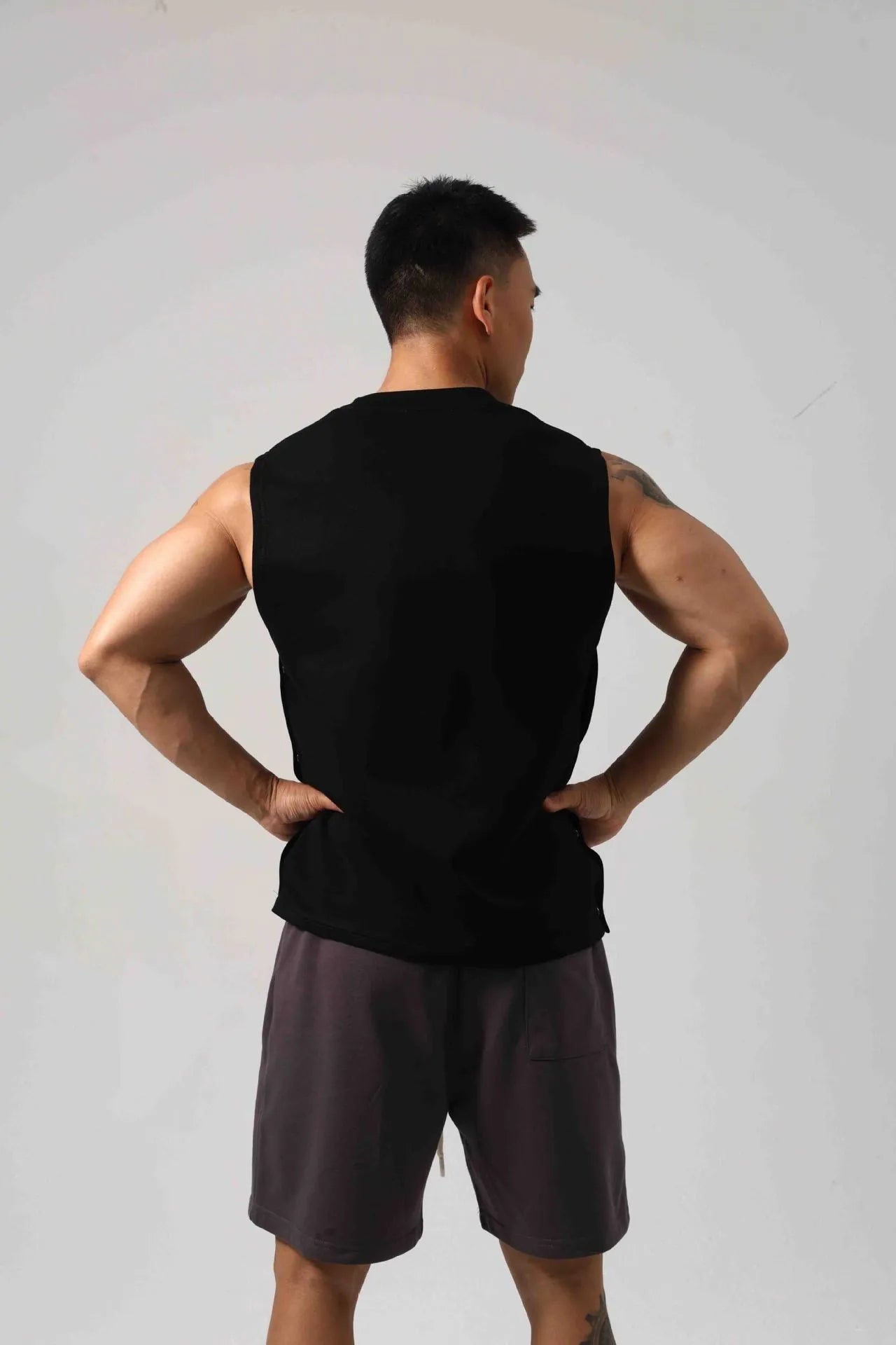 Korean style men's loose cotton fitness vest with hidden side hooks in black.