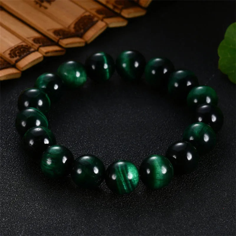 Green Natural Tiger Eye stone bracelet with geometric beads on a wrist.
