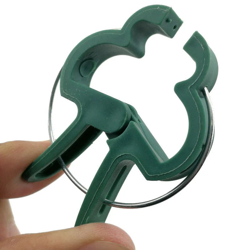 Green plastic and zinc plant fixing clips for supporting tomato vines and climbing plants in the garden.