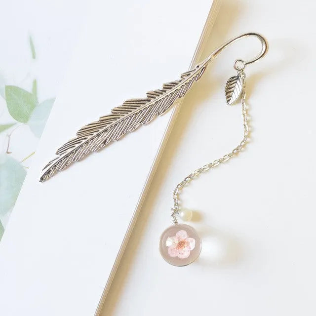 Dried flower specimen encased in metal alloy bookmark pendant measuring 12cm by 2cm