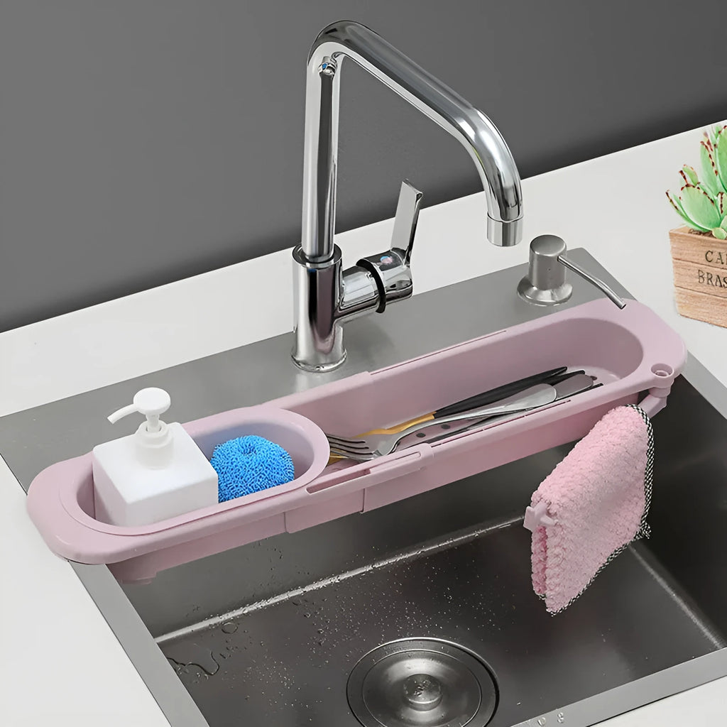 Blue grey adjustable telescopic kitchen sink organiser rack with drainage holes holding a sponge and brush