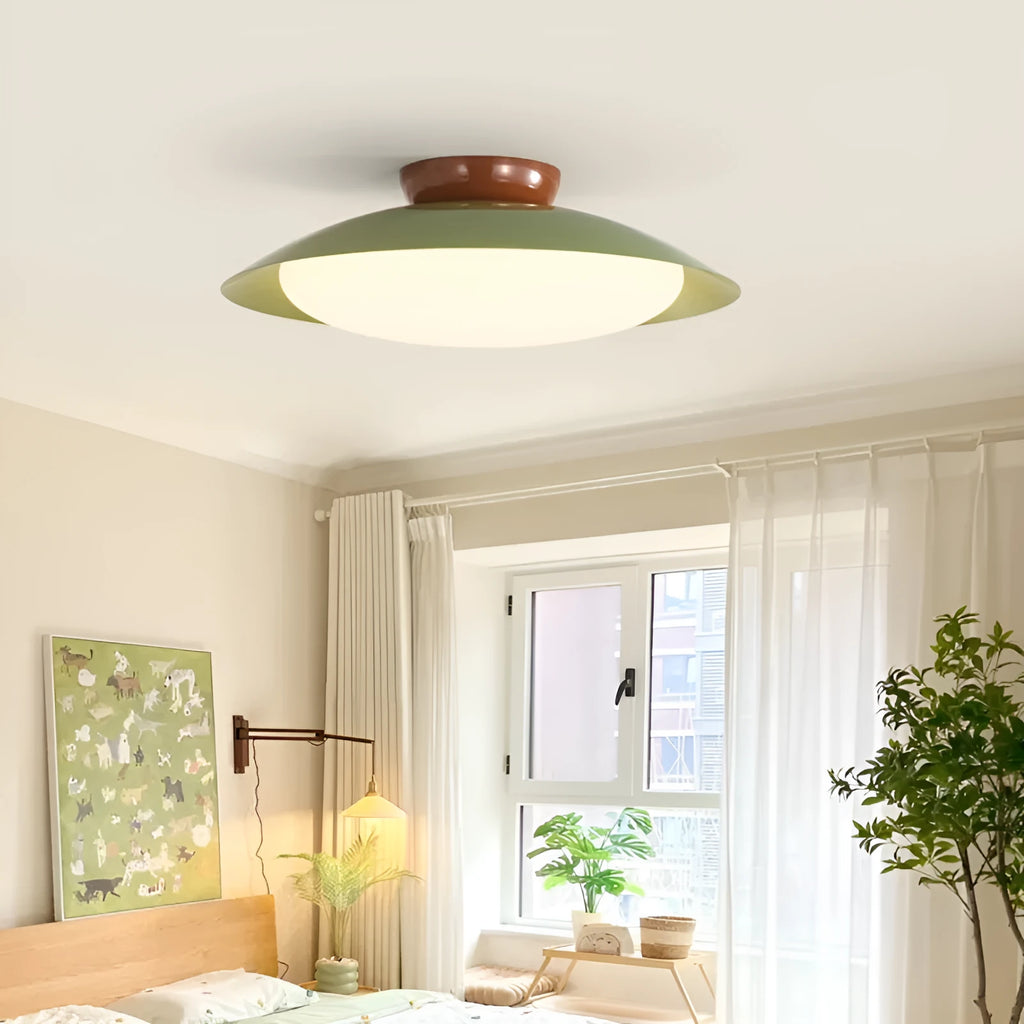 Modern minimalist cream style flying saucer ceiling lamp in mint green on a white ceiling.