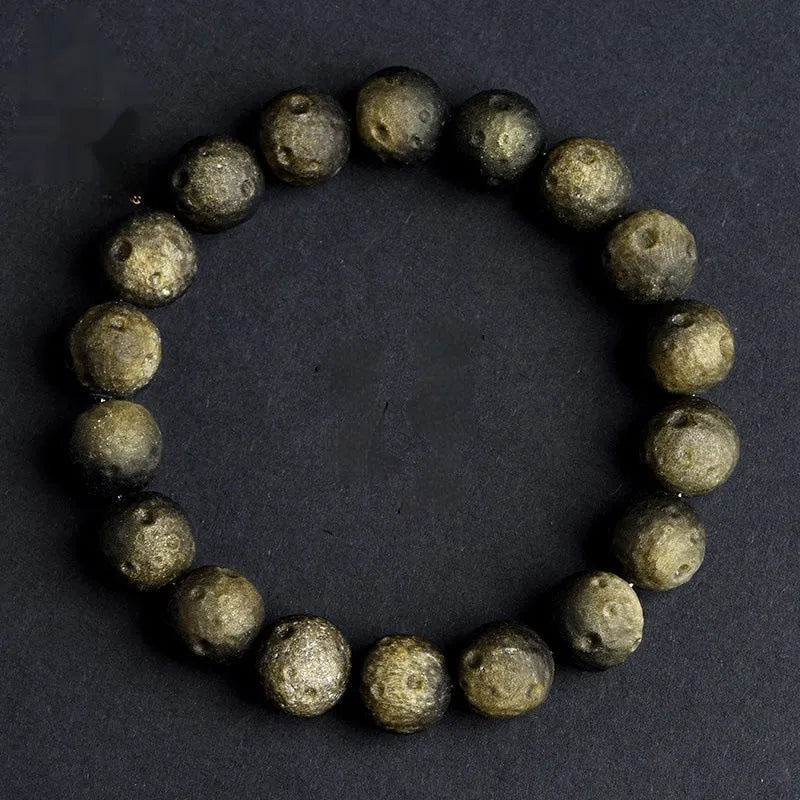 Obsidian crater ball bracelet with textured meteorite-like beads on elasticated cord